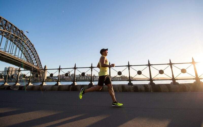 man in yellow tank top running near shore