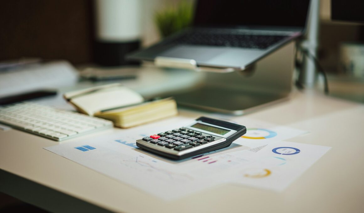 a calculator sitting on top of a table next to a laptop