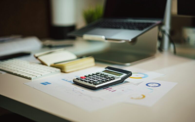 a calculator sitting on top of a table next to a laptop