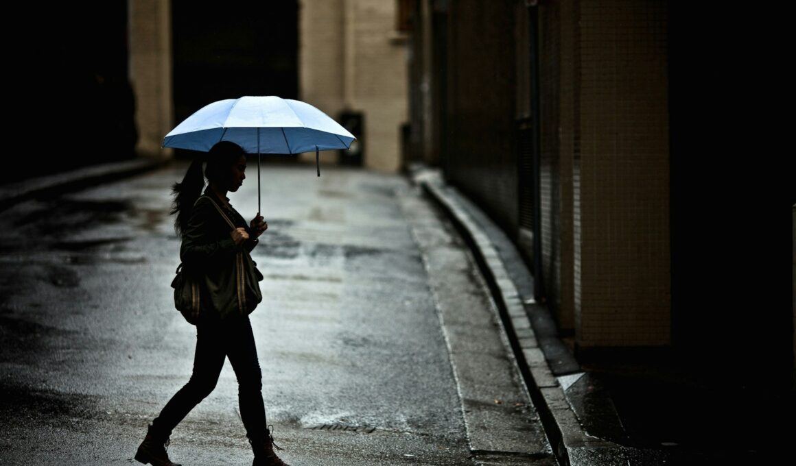 woman with tote bag holding umbrella while crossing street