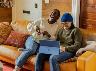 a person sitting on a couch with a laptop