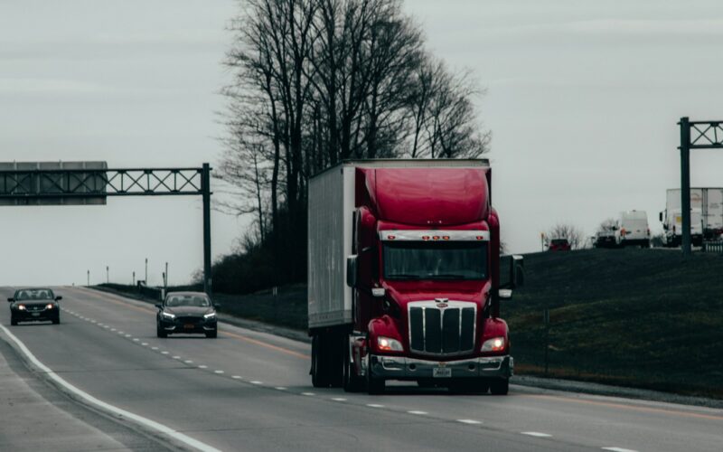red and white truck on road during daytime
