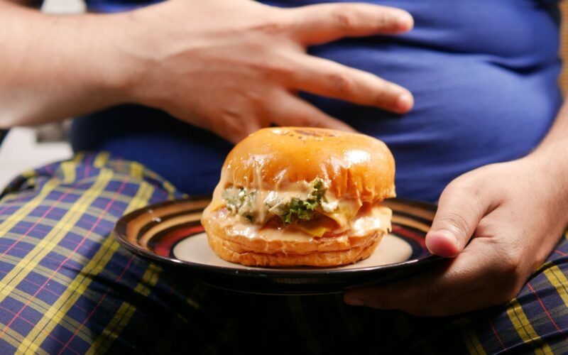 a person holding a plate with a sandwich on it