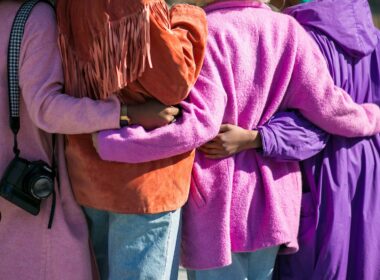 four person holding each others waist at daytime