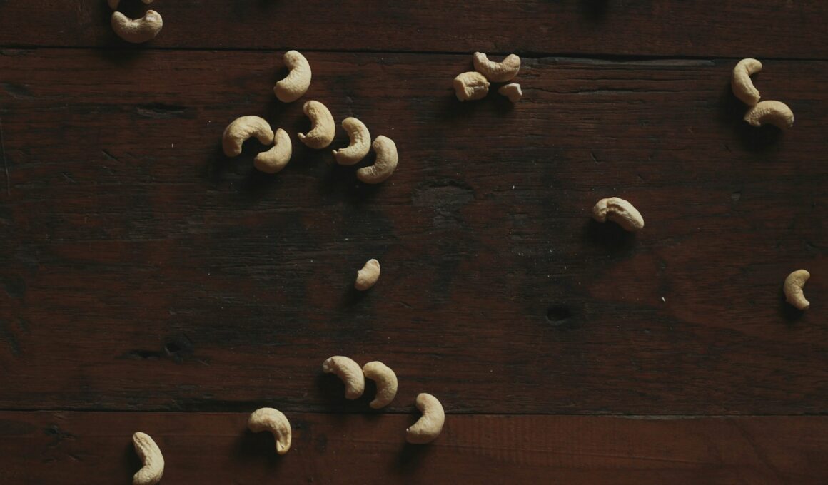 Cashews are scattered on a dark wooden surface.