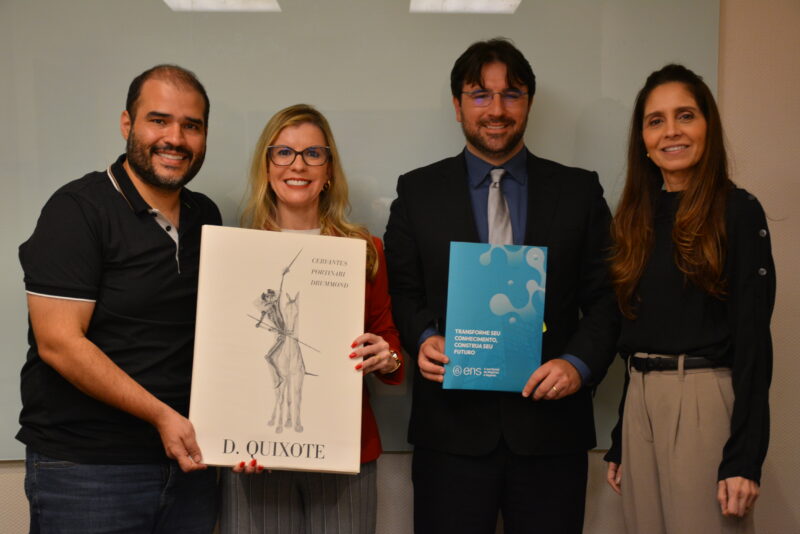Letícia e Leandro Ramos, ao centro, exibindo o contrato de parceria com a ENS e o presente recebido pelos dirigentes Lucas e Paola / Foto: Fernando Gonçalves e João Vitor Silva / Divulgação
