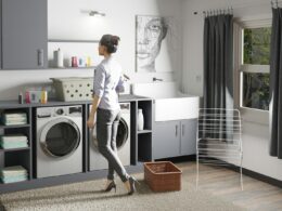 a woman standing in a laundry room next to a washer and dryer