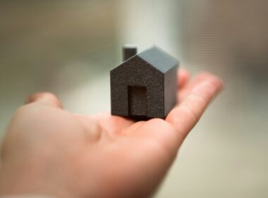 A person holding a small house in their hand