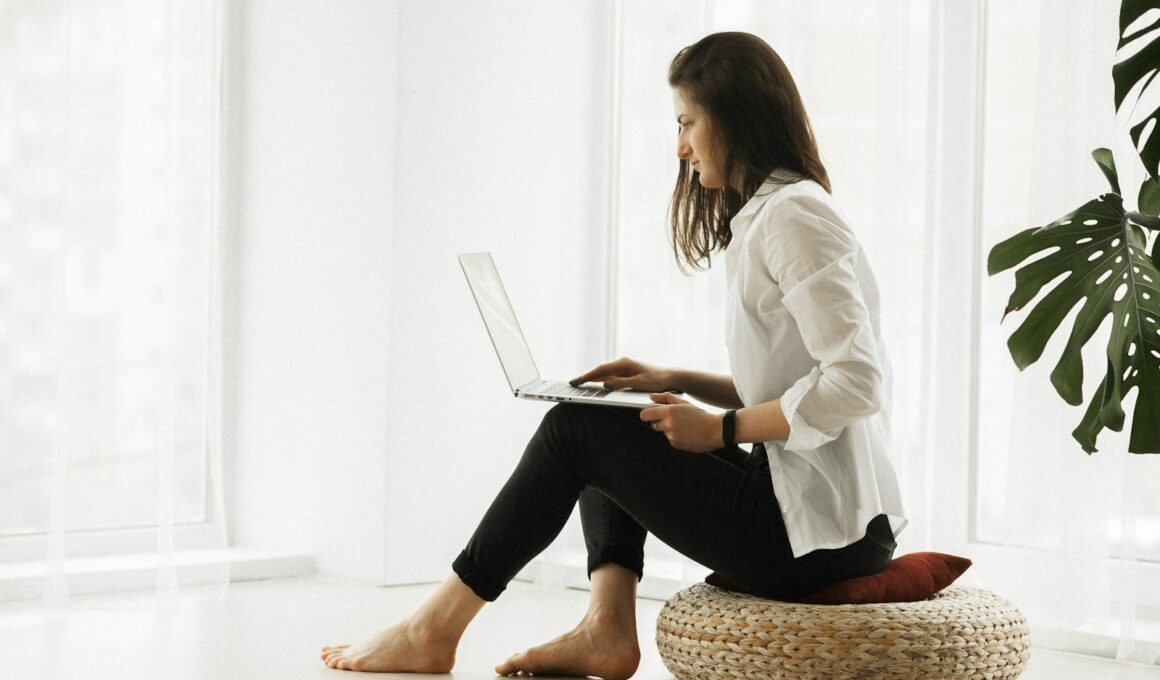 woman in white long sleeve shirt and black pants sitting on brown woven chair