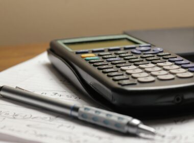 a calculator and a pen sitting on top of a piece of paper