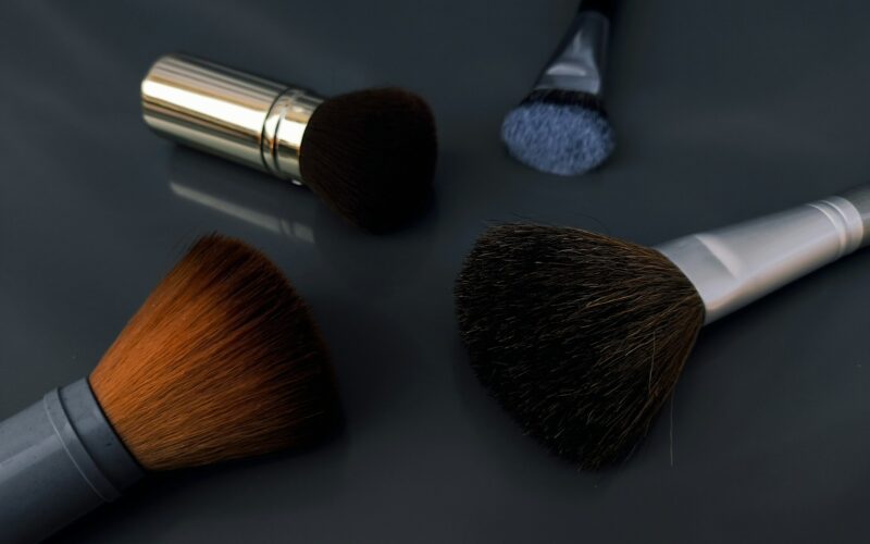 A close up of three makeup brushes on a table