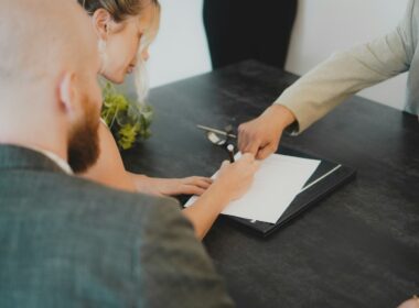 a woman showing a man something on a tablet