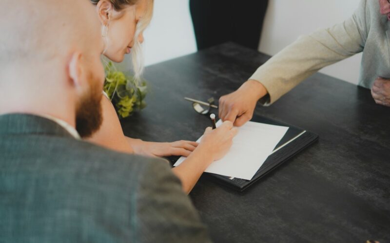a woman showing a man something on a tablet