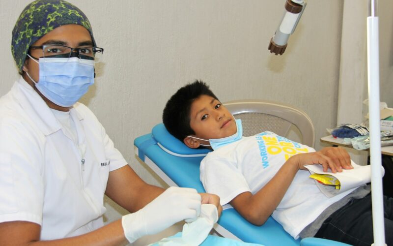 a young boy getting his teeth checked by a dentist