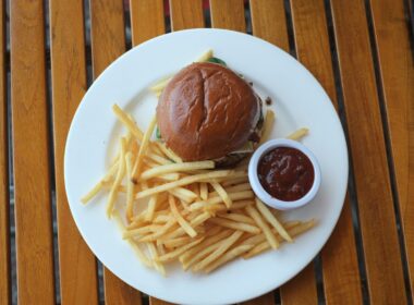 A burger and fries sit on a white plate.