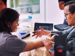man in black shirt holding white smartphone
