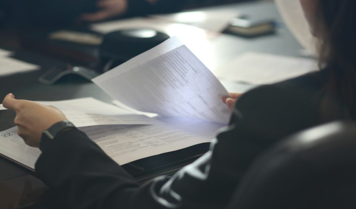 a woman sitting at a table reading a paper