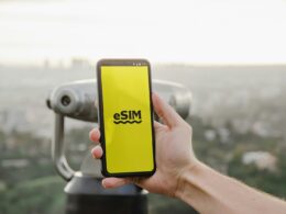 a person holding up a cell phone with a logo on it