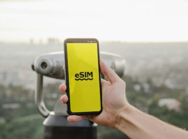 a person holding up a cell phone with a logo on it