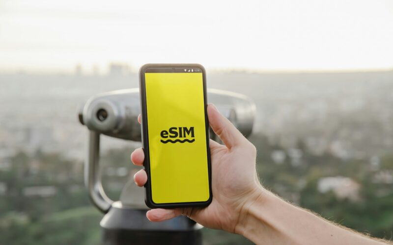 a person holding up a cell phone with a logo on it