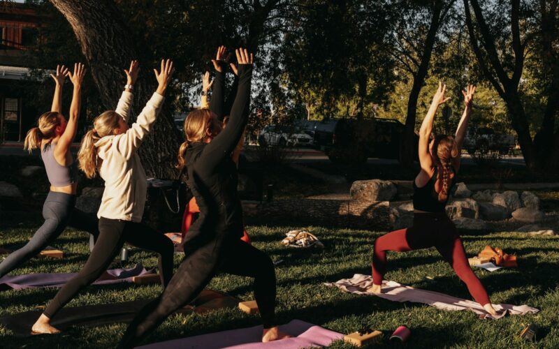 a group of people doing yoga in a park