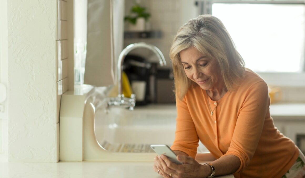 woman in orange long sleeve shirt using white smartphone