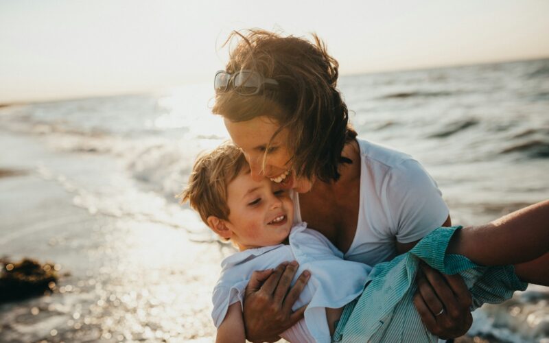 photo of mother and child beside body of water