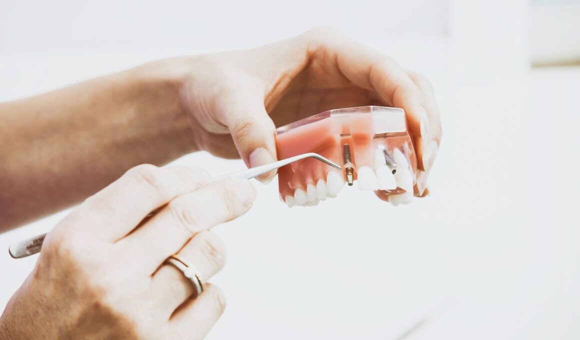 person wearing silver-colored ring while holding denture