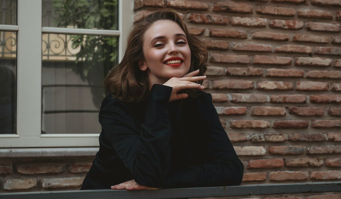 a woman leaning on a rail in front of a brick building